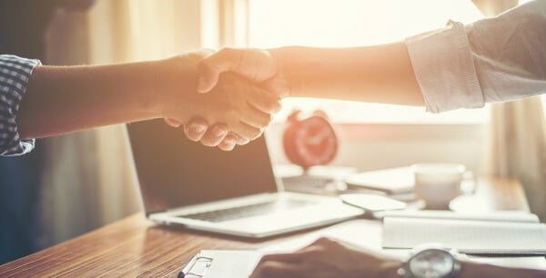 Cliente e fornecedor em um aperto de mãos firme e confiante confiante.